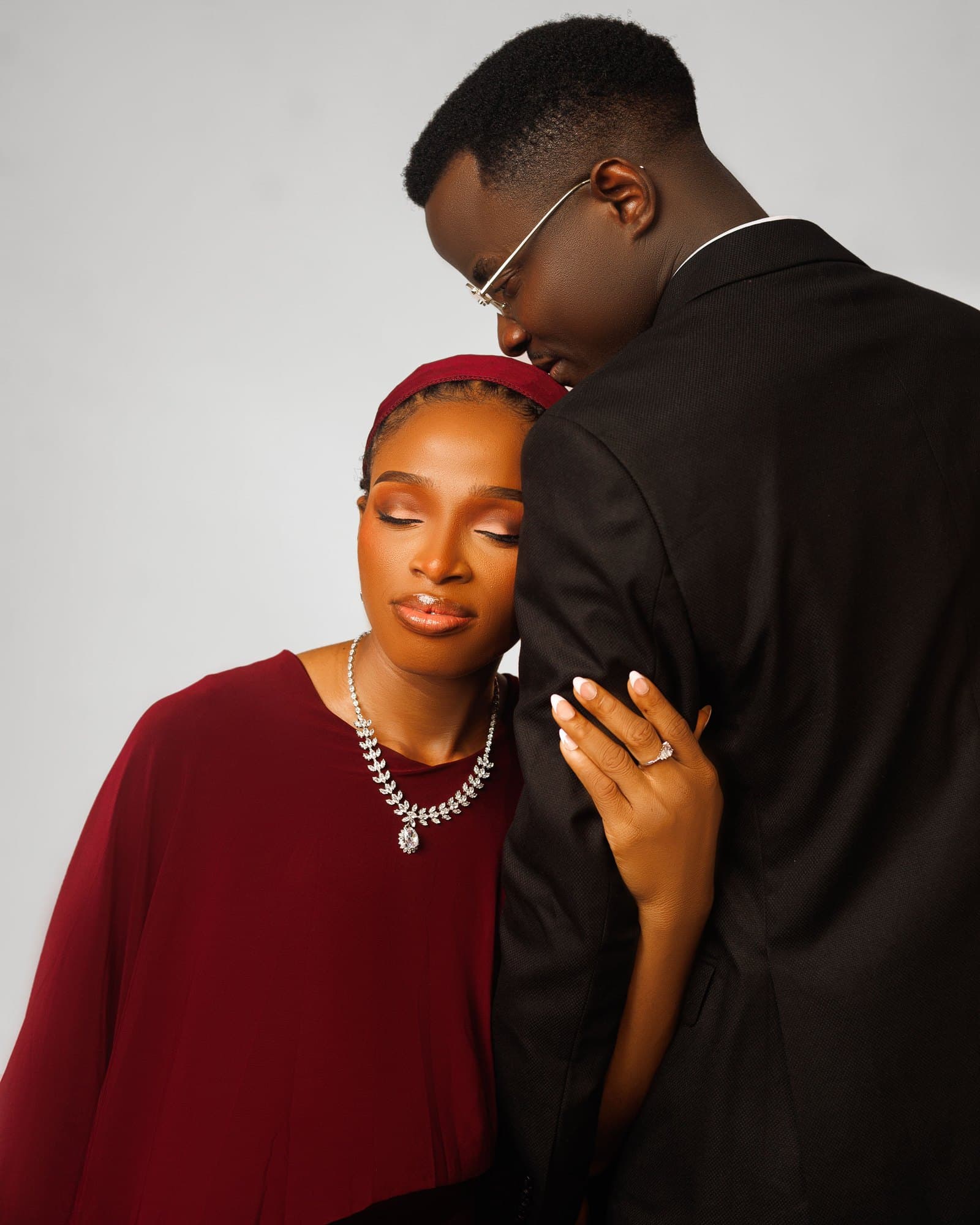Intimate black and white portrait of Scholarstica leaning on Joseph with engagement ring showing